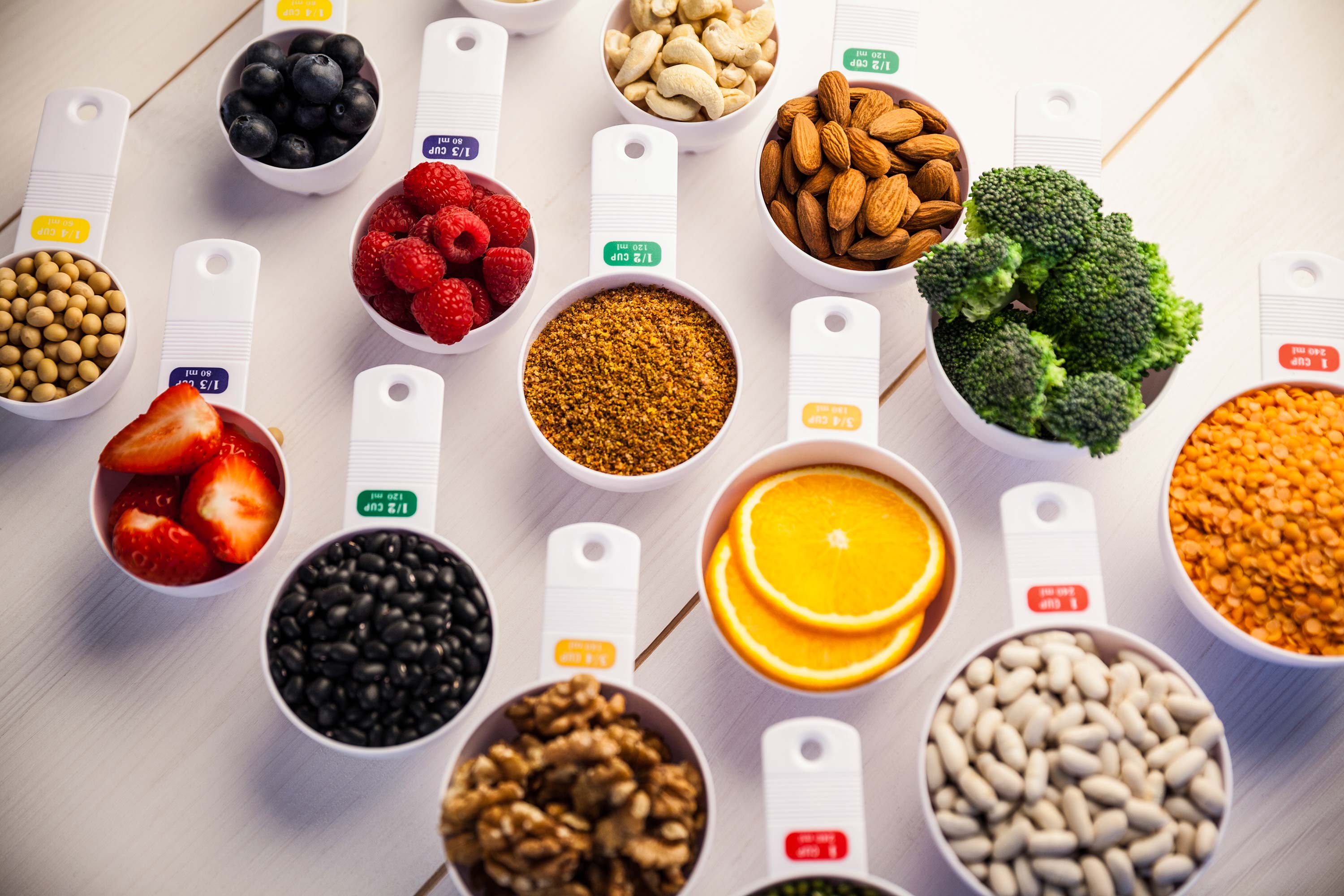 Portion cups of healthy ingredients on wooden table