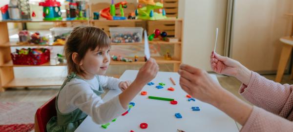 Child in therapy holding flash cards