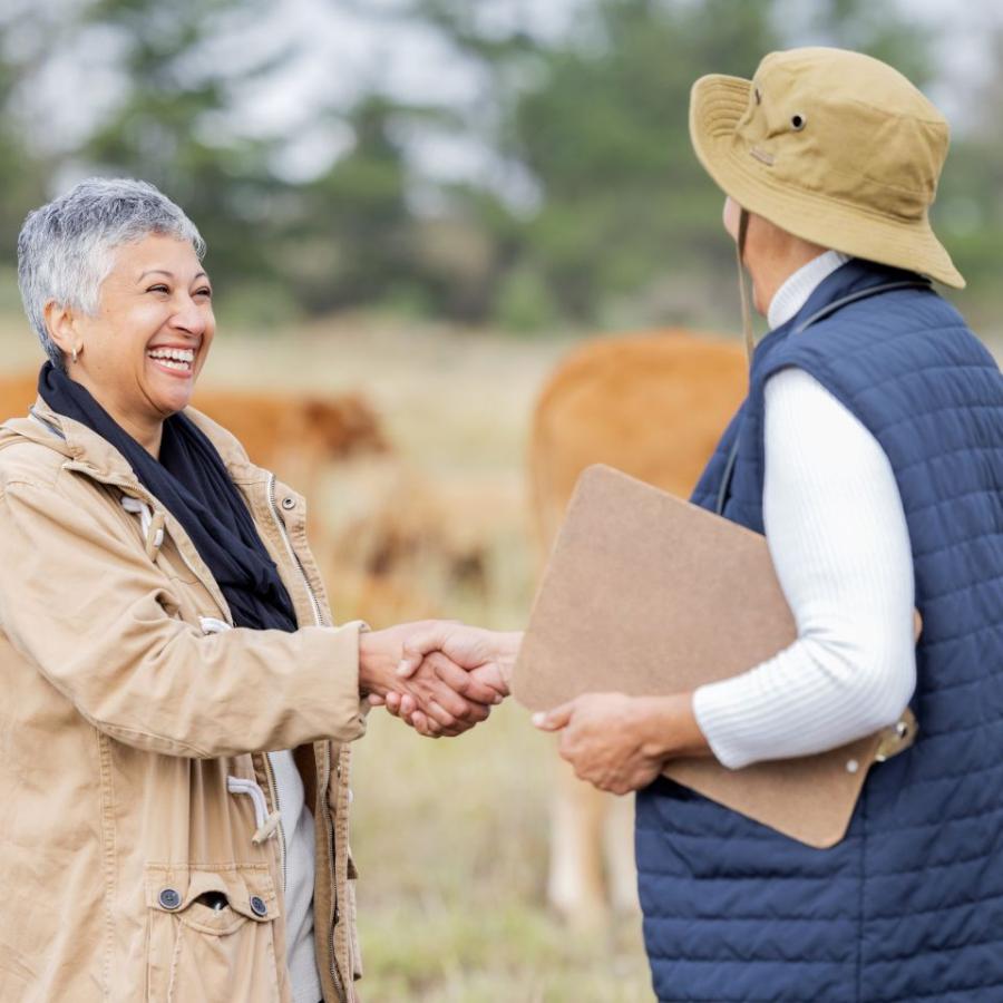 two women meeting in farm with handshake